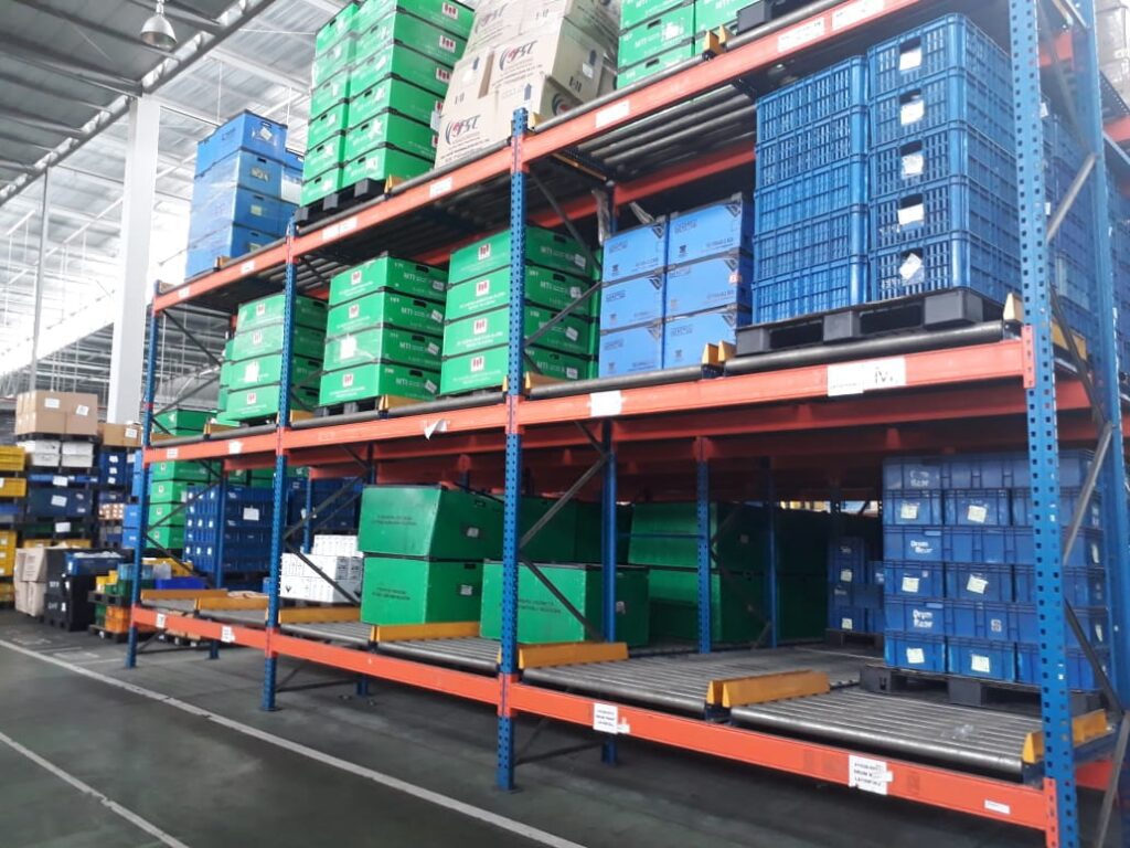 Pallet flow racking system with roller tracks and warehouse storage crates