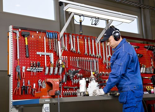Treston workshop operator using a heavy-duty bench with red tool panels and workshop tools